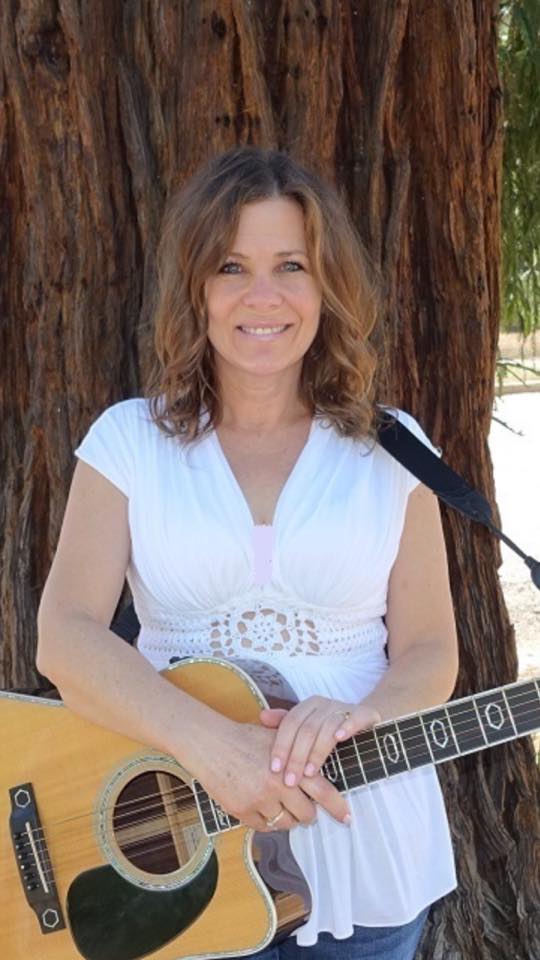 Jennifer with guitar by a tree